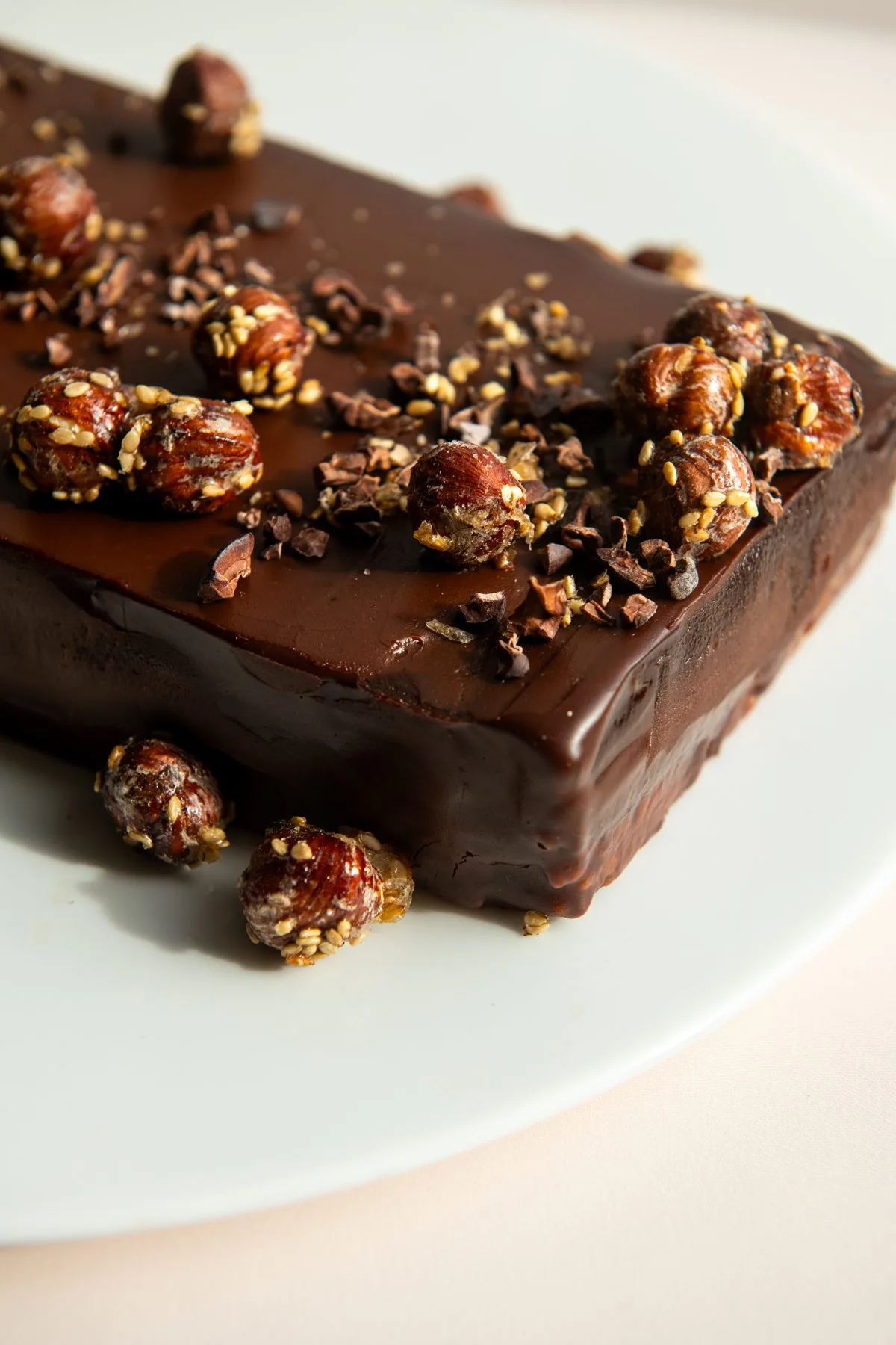 Gros plan sur une bûche végétale chocolat, noisettes caramélisées au sésame